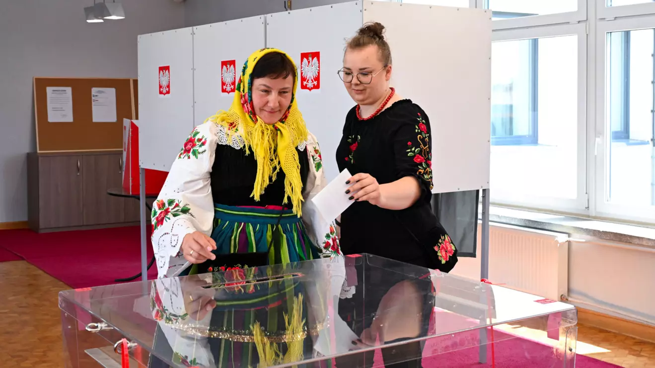 A woman in traditional clothes votes during the second round of presidential election at a polling station in Gluchow, Poland, June 1, 2025. Reuters/Kasia Strek