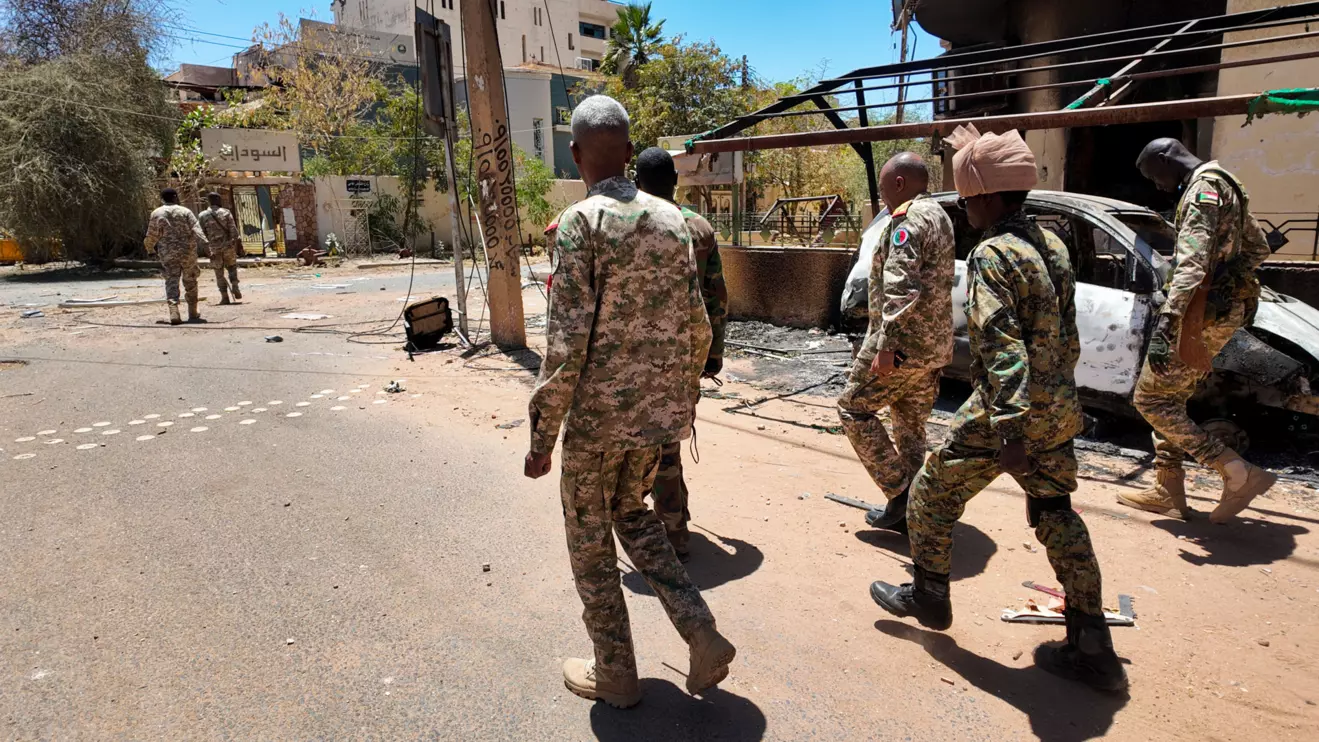 Members of the Sudanese army walk next to destroyed military vehicles after a battle with Rapid Support Forces (RSF) in the capital Khartoum, Sudan March 25, 2025. Reuters
