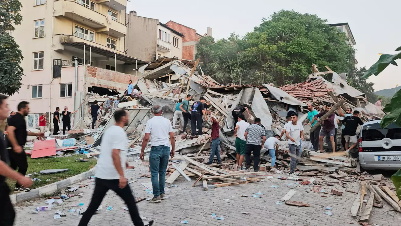 People rush to a collapsed building to search for survivors after an earthquake in Sindirgi in the western Balikesir province, Turkey, August 10, 2025. Ihlas News Agency (IHA) via Reuters