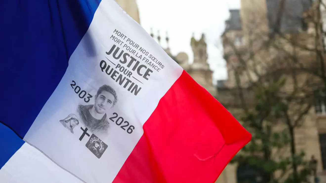 A french flag with a 'Justice for Quentin' message is displayed as people gather to pay tribute to Quentin, an activist who died from injuries sustained during a beating on February 12 in Lyon, during a demonstration at the Place de la Sorbonne in Paris, France, February 15, 2026. Reuters