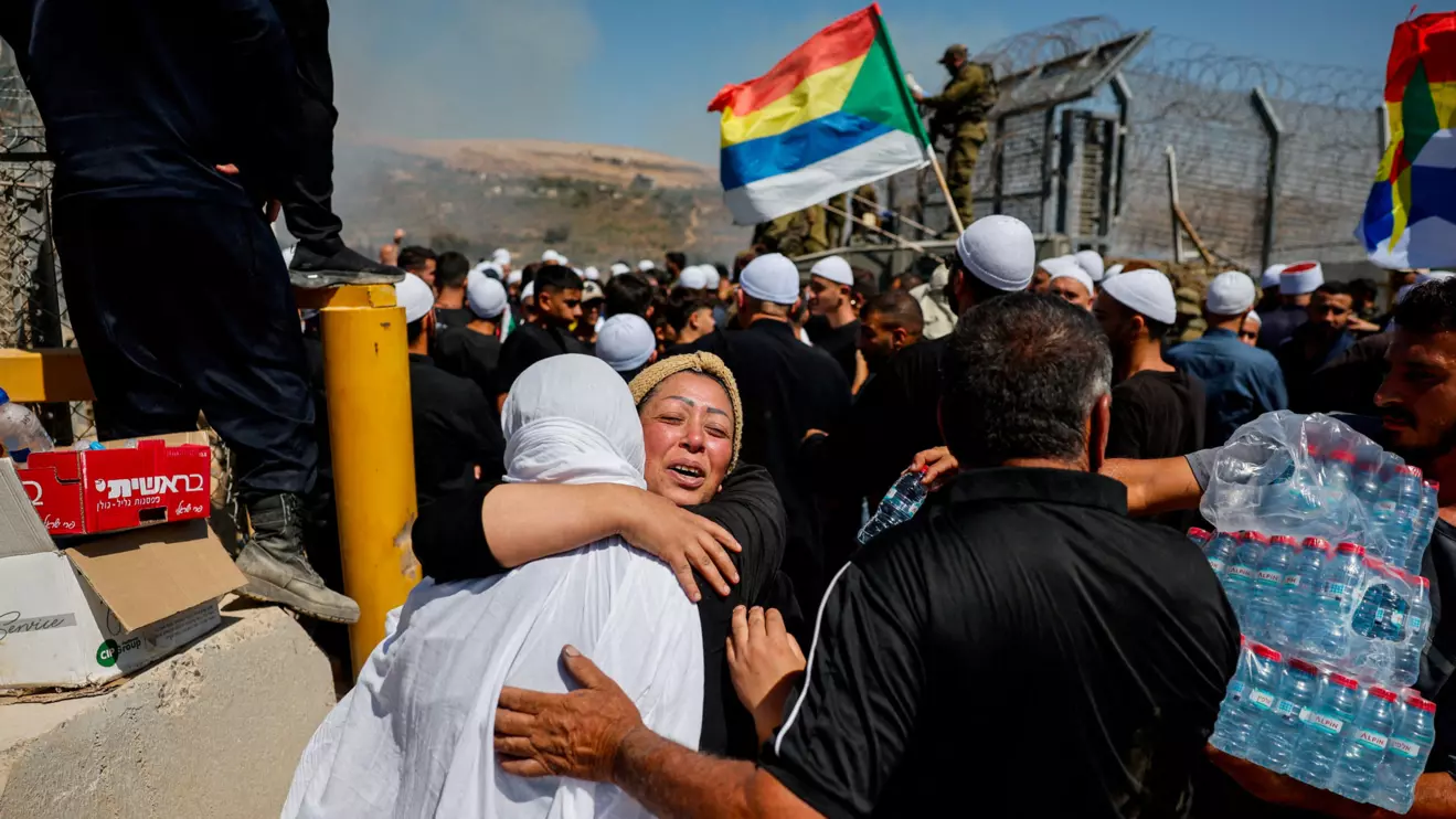A Druze woman from Syria, meets her sister as she crosses to the Israeli side from the open border to check on her family members, amid the ongoing conflict in the Druze areas in Syria, near the ceasefire line between the Israeli-occupied Golan Heights and Syria, July 16, 2025. Reuters/Ammar Awad
