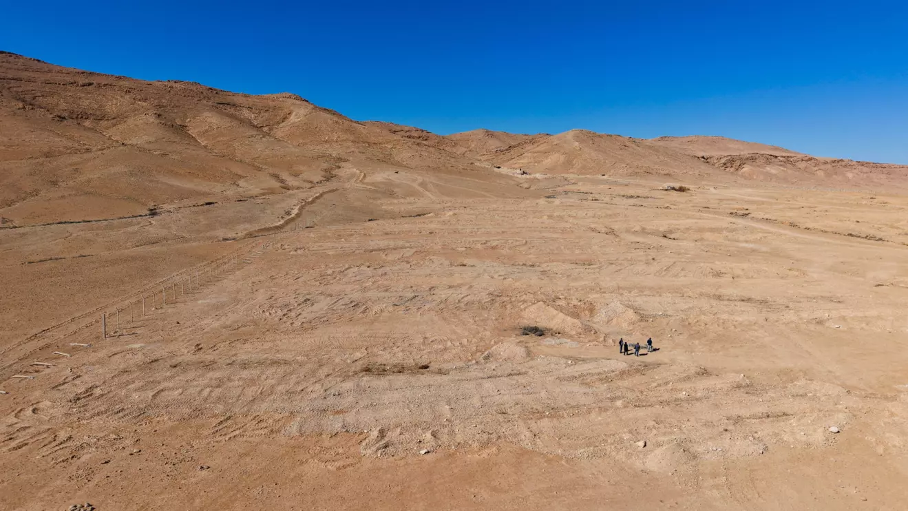 Four people walk through the desert mass grave created under the Assad government near the town of Dhumair, Syria, February 27, 2025. Reuters/Khalil Ashawi