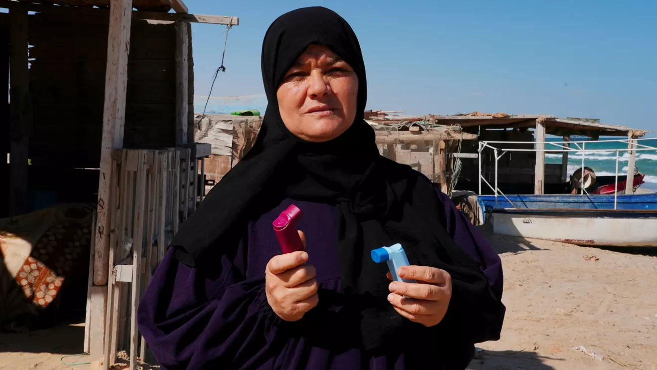 Maha Mahmoud, a Gabes resident suffering from a rare form of cancer and asthma, holds her inhalers while posing for the camera in Gabes, Tunisia, October 16, 2025. Reuters/Jihed Abidellaoui