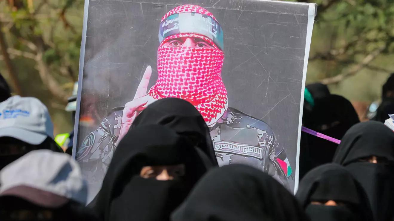 A poster of Abu Ubaida, the spokesman of the al-Qassam Brigades, is carried by university students during a rally to show support for the Palestinians in the Gaza Strip and the recent Houthi strikes on ships in the Red Sea and the Gulf of Aden, in Sanaa, Yemen January 31, 2024. Reuters/Khaled Abdullah