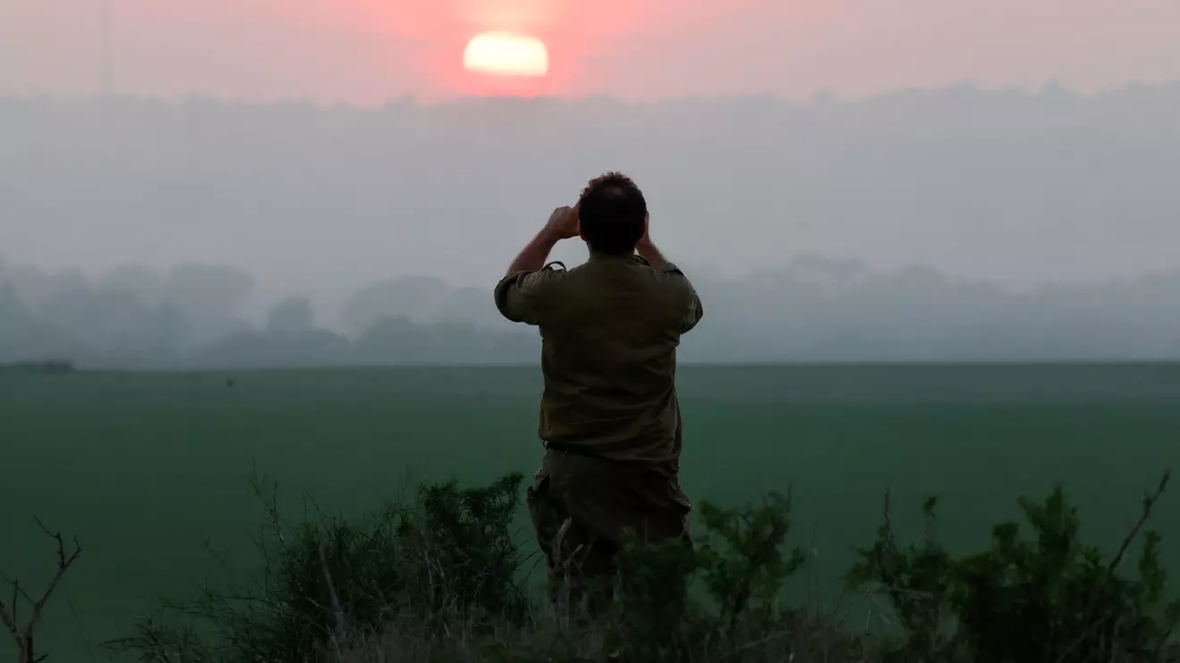 An Israeli soldier takes a picture of the sunset, amid the ongoing conflict between Israel and the Palestinian Islamist group Hamas, near the Israel-Gaza border, in Israel, December 30, 2023. Reuters/Amir Cohen
