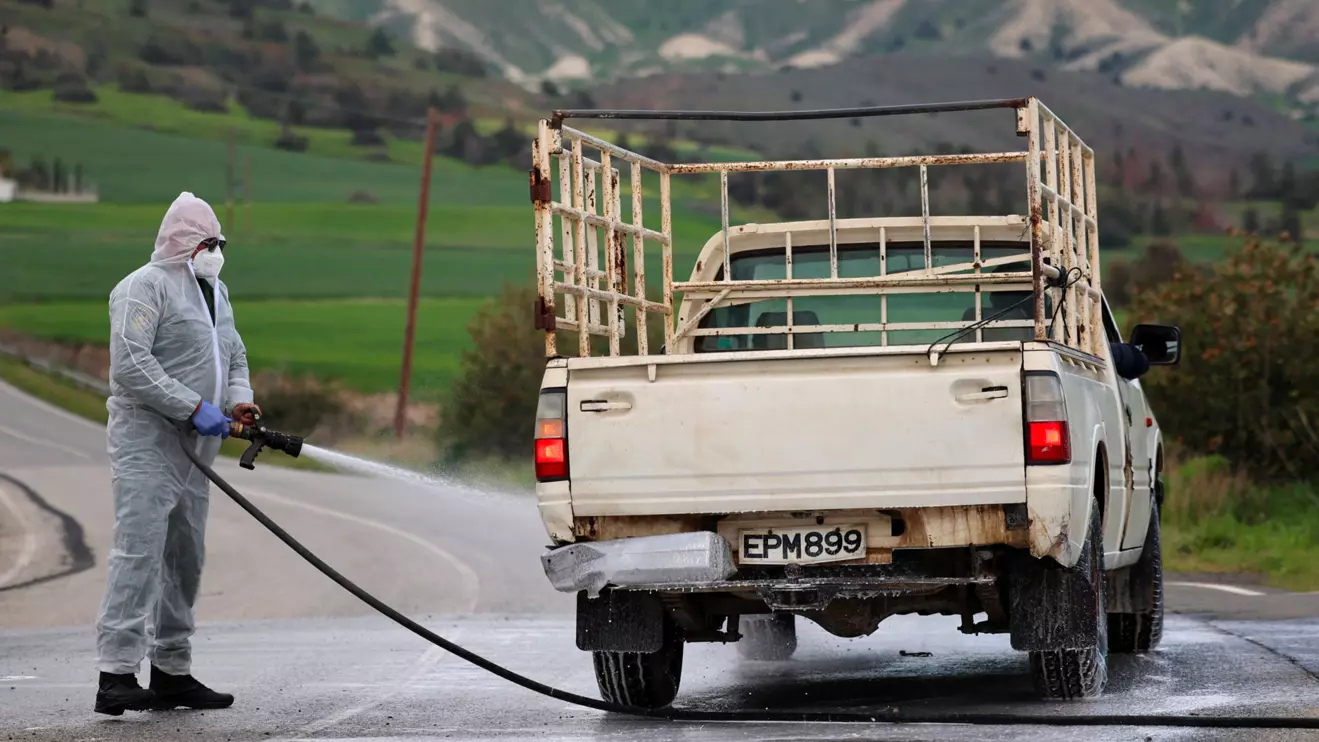 Man in a hazmat suit disinfects a vehicle and the road leading to farming units Oroklini, Cyprus, following cases of foot and mouth disease among livestock, Cyprus February 24, 2026. Reuters/Yiannis Kourtoglou