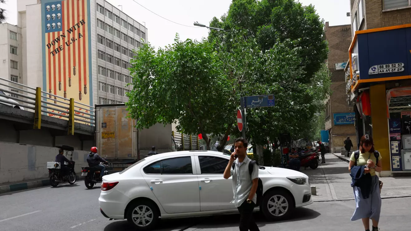 People walk near an anti-U.S. mural on a building in Tehran, Iran, May 19, 2026. Majid Asgaripour/WANA (West Asia News Agency) via Reuters
