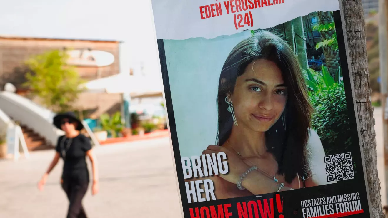 A woman walks near a poster showing Eden Yerushalmi, who was taken hostage by Hamas during the October 7 attacks, and whose body has been recovered from a tunnel in the Rafah area of the Gaza Strip, in Tel Aviv, Israel September 1, 2024. Reuters/Florion Goga