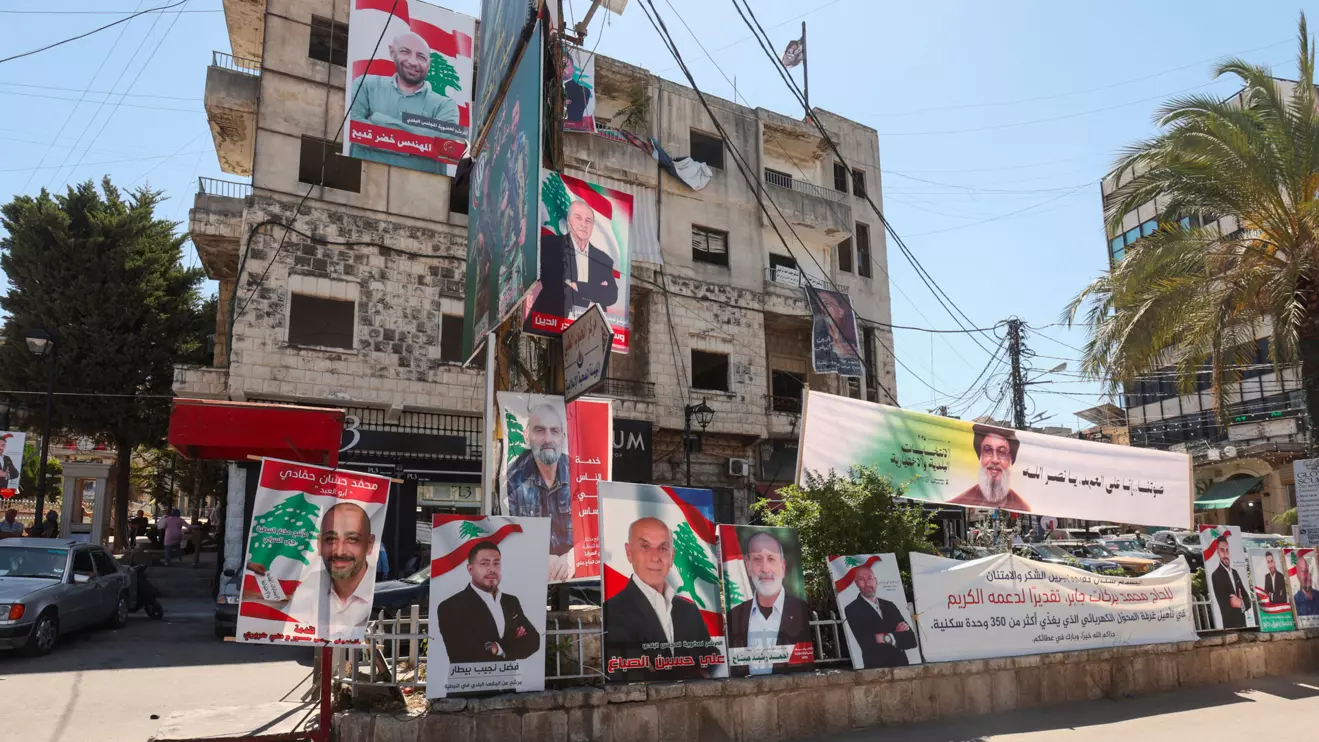 A banner depicting late Hezbollah leader Hassan Nasrallah and campaign poster of the candidates running for municipal elections, are placed along a street in Nabatieh, southern Lebanon May 19, 2025. Reuters/Aziz Taher