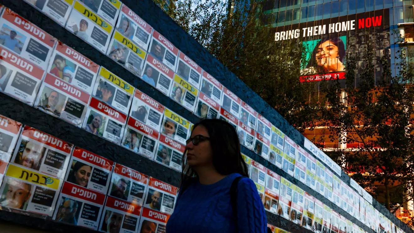 A woman walks past posters with pictures of hostages kidnapped in the deadly October 7 attack on Israel by the Palestinian Islamist group Hamas from Gaza, in Tel Aviv, March 25, 2024. Reuters/Carlos Garcia Rawlins