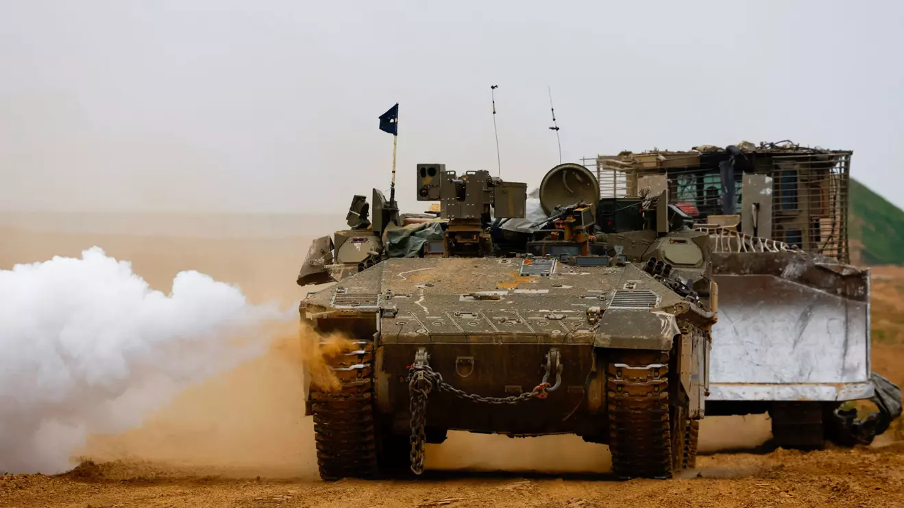 An Israeli armoured personnel carrier (APC) and a D9 bulldozer maneuver near the Israel-Gaza border, February 23, 2024. Reuters/Susana Vera