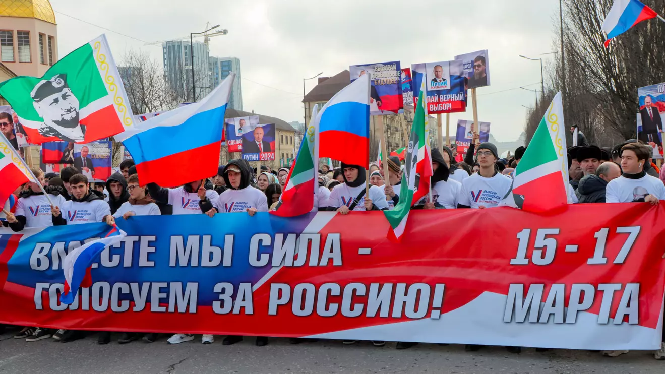 People, including supporters of Russian incumbent President and presidential candidate Vladimir Putin, take part in a procession organized on the occasion of the upcoming presidential election, in the Chechen capital Grozny, Russia, March 10, 2024. A slogan on the banner reads: "Together we are a force - vote for Russia!" Reuters/Chingis Kondarov