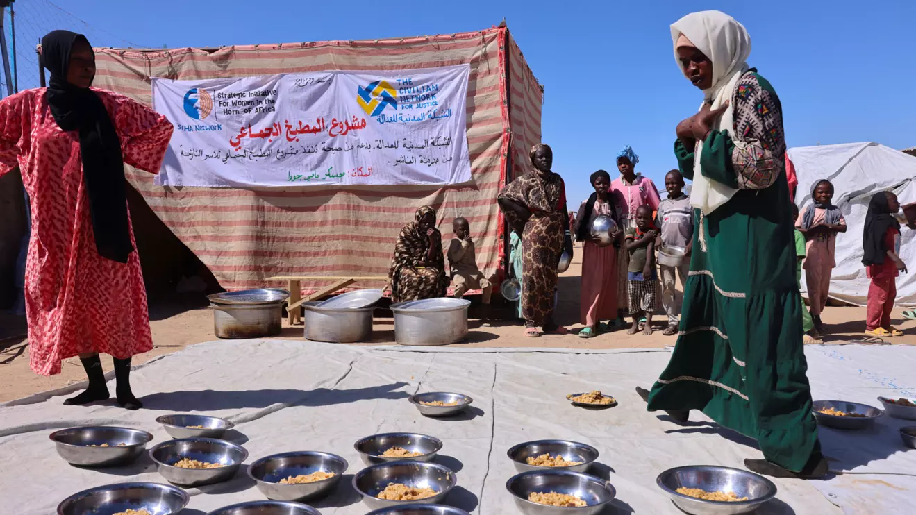Najwa Isa Adam (L), 32, a Sudanese refugee from al-Fashir, prepares bowls of pasta and meat for orphaned children and newly arriving refugee families using donated money at the Tine transit camp in eastern Chad, November 22, 2025. Najuwa says she was held captive at gunpoint by four Rapid Support Forces (RSF) fighters who repeatedly raped her amid the conflict with the Sudanese army. Reuters/Amr Abdallah Dalsh